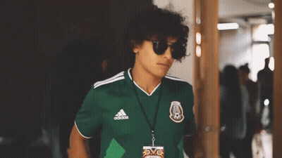 A Young Man Wearing Sunglasses And A Green Adidas Jersey GIF