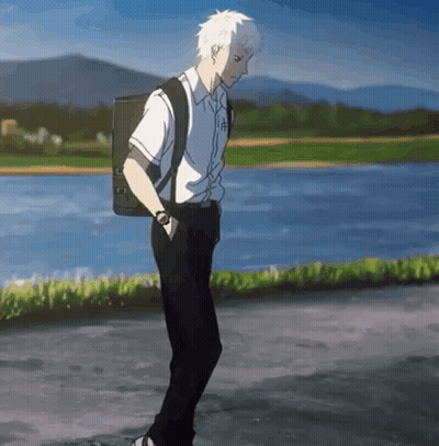 A Young Man With A Backpack Is Walking Down A Street . GIF