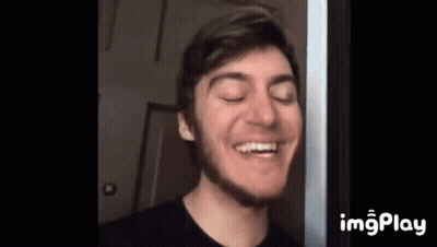 A Young Man With A Beard Is Smiling With His Eyes Closed And His Mouth Open . GIF