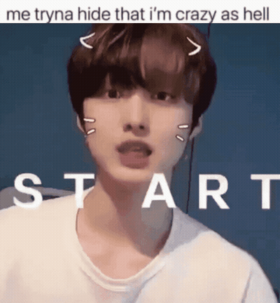 A Young Man With A Cat Ear On His Head Is Standing In Front Of A Sign That Says Start GIF