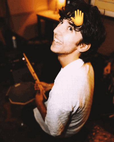 A Young Man With A Hand On His Head Playing Drums GIF