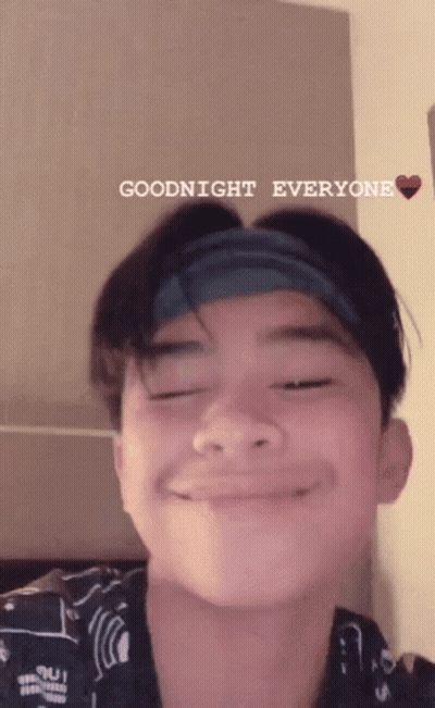 A Young Man With A Headband On His Head Is Smiling And Saying Goodnight Everyone . GIF