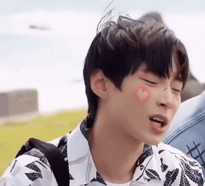 A Young Man With A Heart On His Cheek Is Making A Face . GIF