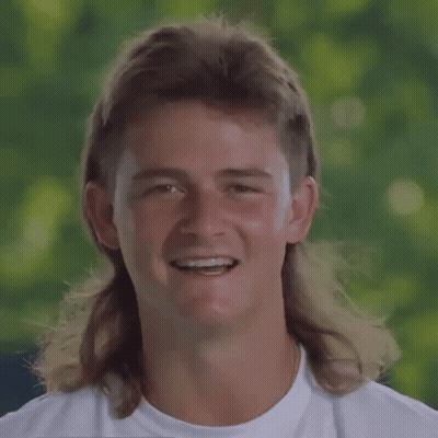 A Young Man With A Mullet And Braces On His Teeth Is Smiling . GIF