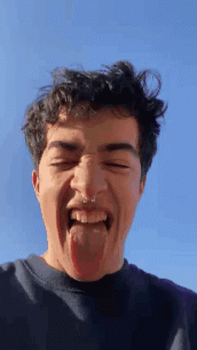 A Young Man With A Nose Ring Sticking His Tongue Out GIF