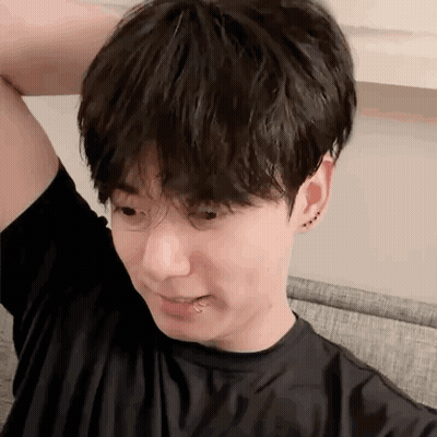 A Young Man With A Piercing In His Lip Is Sitting On A Couch With His Hand On His Head . GIF