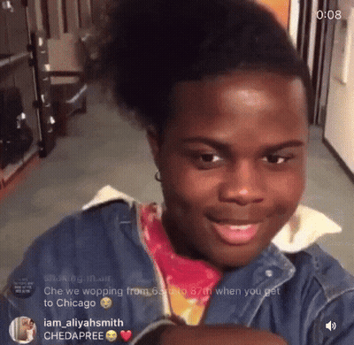 A Young Man With A Ponytail Is Smiling And Looking At The Camera With The Time Of 0:08 Behind Him GIF