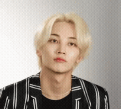 A Young Man With Blonde Hair And Red Lipstick Is Wearing A Black And White Striped Jacket And A Black Shirt . GIF