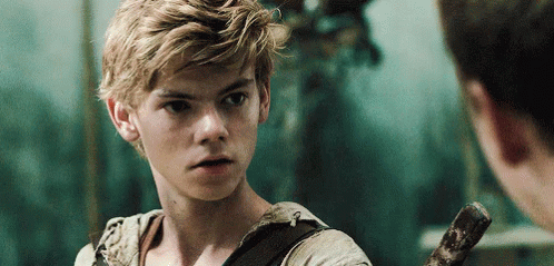 A Young Man With Blonde Hair Is Holding A Sword And Looking At Another Man . GIF