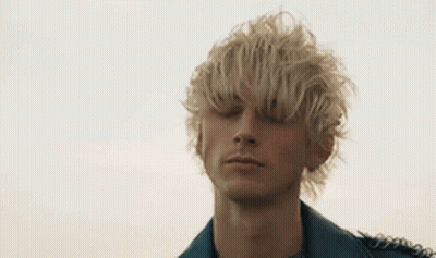 A Young Man With Blonde Hair Is Wearing A Leather Jacket And A Black Shirt . GIF