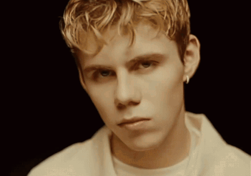 A Young Man With Blonde Hair Is Wearing A White Shirt GIF