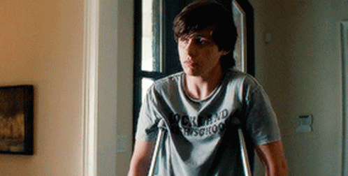 A Young Man With Crutches Is Wearing A Rock And Roll Shirt GIF
