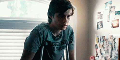 A Young Man With Crutches Is Wearing A Shirt That Says Chand Bistro . GIF
