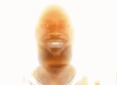 A Young Man With Curly Hair And A Beard Smiles GIF