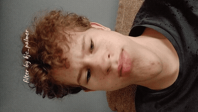 A Young Man With Curly Hair Is Laying On A Couch With The Words Filter By Kic Palmer Written On The Bottom GIF