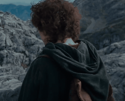 A Young Man With Curly Hair Is Standing In Front Of Mountains GIF