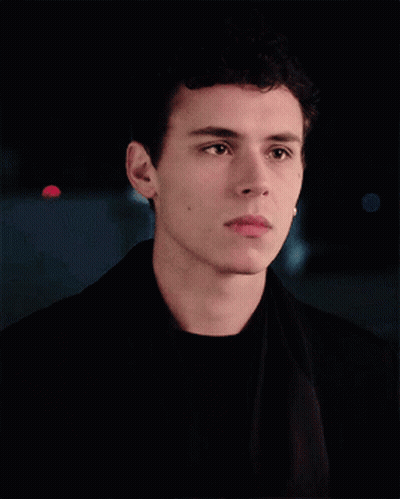 A Young Man With Curly Hair Is Wearing A Black Jacket GIF