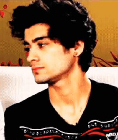 A Young Man With Curly Hair Is Wearing A Black Sweater GIF