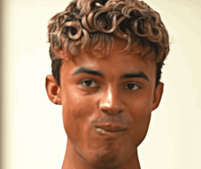 A Young Man With Curly Hair Looks At The Camera GIF