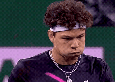 A Young Man With Curly Hair Wearing A Headband And A Necklace GIF