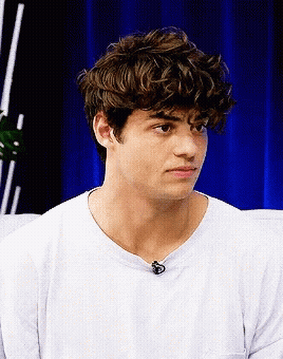 A Young Man With Curly Hair Wearing A White T-Shirt GIF