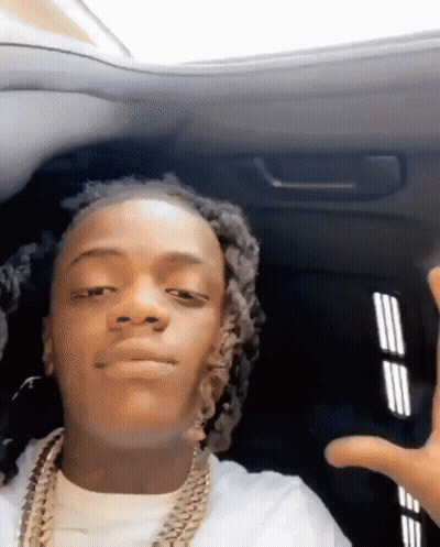 A Young Man With Dreadlocks Is Sitting In The Back Seat Of A Car And Making A Funny Face . GIF