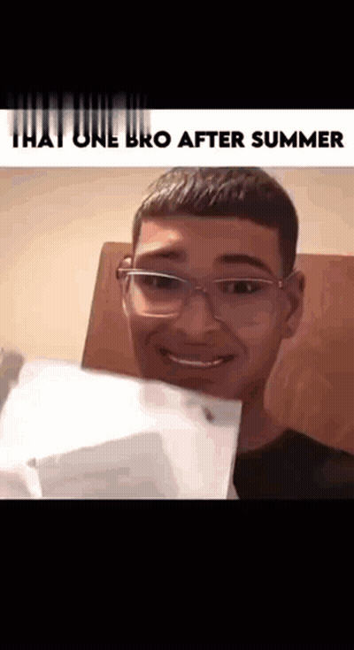A Young Man With Glasses Is Smiling And Holding A Piece Of Paper . GIF