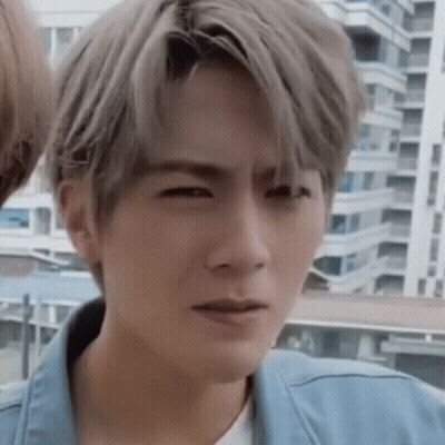 A Young Man With Gray Hair Is Making A Funny Face . GIF