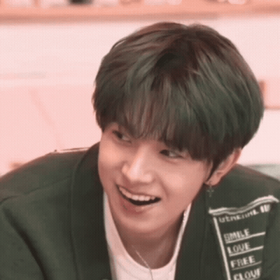 A Young Man With Green Hair Is Smiling And Wearing A Shirt That Says Smile Love Free And Flour GIF