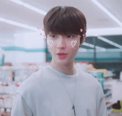 A Young Man With Hearts Drawn On His Face And A Necklace With The Number 1 On It GIF
