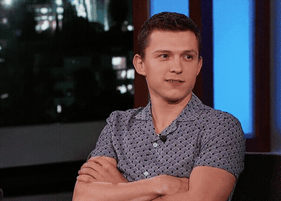 A Young Man With His Arms Crossed And A Microphone On His Shirt GIF