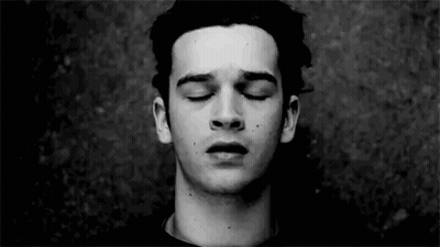 A Young Man With His Eyes Closed In A Black And White Photo . GIF