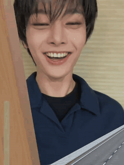 A Young Man With His Eyes Closed Is Smiling GIF