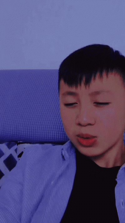 A Young Man With His Eyes Closed Is Wearing A Blue Shirt GIF