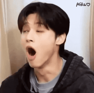 A Young Man With His Mouth Open Is Wearing A Black Jacket . GIF