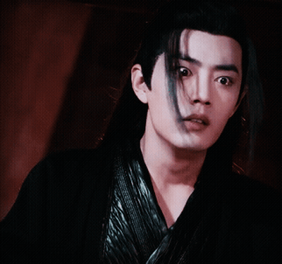 A Young Man With Long Black Hair Is Wearing A Black Shirt GIF