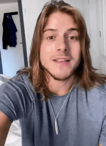 Young Man With Long Hair And Blue Shirt GIF