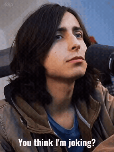 A Young Man With Long Hair Is Sitting In Front Of A Microphone And Says " You Think I 'M Joking " GIF