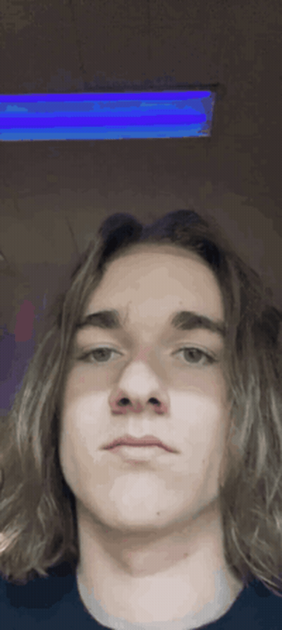 A Young Man With Long Hair Is Taking A Selfie With A Blue Light Behind Him . GIF