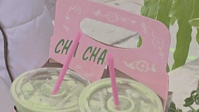 A Young Man With Pink Hair Is Smiling And Holding A Toothpick In His Mouth . GIF