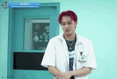 A Young Man With Red Hair Is Standing In Front Of A Blue Door And A Sign That Says Episode 1 GIF
