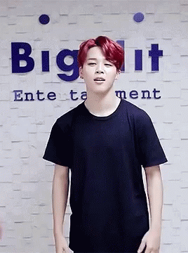 A Young Man With Red Hair Is Standing In Front Of A Sign That Says Big It Entertainment GIF