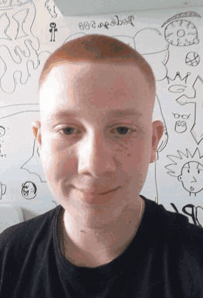 A Young Man With Red Hair Is Standing In Front Of A White Board With Drawings On It . GIF