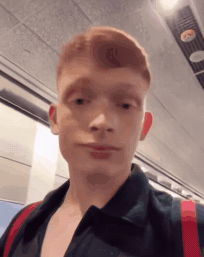 A Young Man With Red Hair Is Wearing A Black Shirt GIF