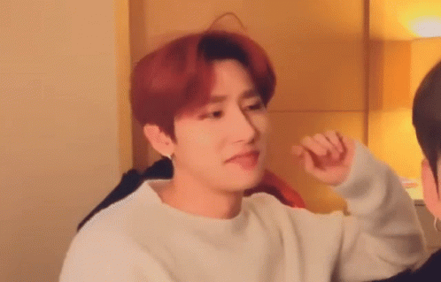 A Young Man With Red Hair Is Wearing A White Sweater And Making A Funny Face . GIF