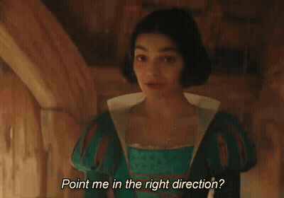 A Young Woman In A Green Dress Is Standing In A Room And Smiling . GIF