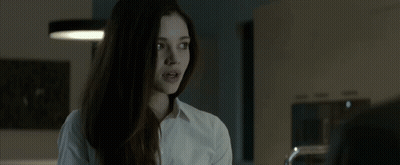 A Young Woman In A White Shirt Is Talking To A Man In A Kitchen . GIF
