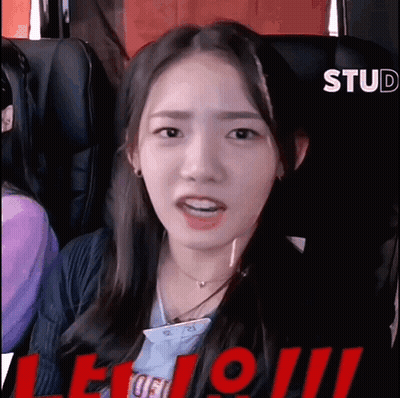 A Young Woman Is Sitting In A Roller Coaster Looking At The Camera . GIF