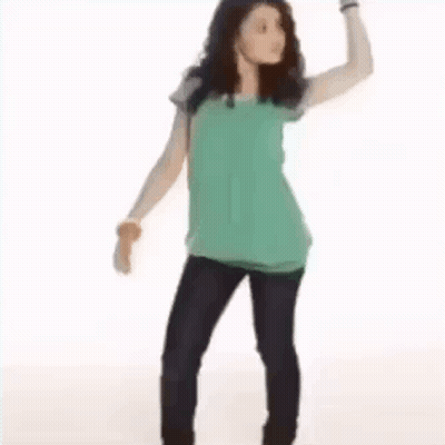 A Young Woman Is Standing With Her Hands On Her Hips . GIF