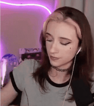 A Young Woman Wearing Headphones And A Choker Is Sitting In Front Of A Computer . GIF